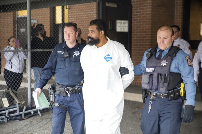 Ramapo police officers escort Grafton Thomas from Ramapo Town Hall to a police vehicle, Sunday, Dec. 29, 2019, in Ramapo, N.Y. (AP Photo/Julius Constantine Motal)