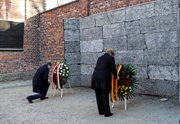 German Chancellor Angela Merkel , right, and Polish Prime Minister Mateusz Morawiecki , right, place flowers at the Death Wall during their visit of the former Nazi death camp of Auschwitz-Birkenau in Oswiecim, Poland on Friday, Friday, Dec. 6, 2019. (Photo/Markus Schreiber)