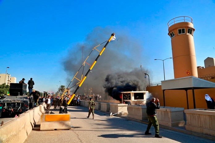 Protesters burn property in front of the U.S. embassy compound, in Baghdad, Iraq, Tuesday, Dec. 31, 2019. (AP Photo/Khalid Mohammed)