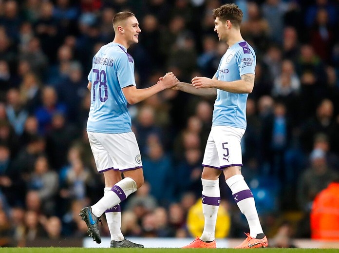 Manchester City's Taylor Harwood-Bellis, right, celebrates scoring his side's third goal of the game with teammate John Stones during the English FA Cup third round soccer match between Manchester City and Port Vale at the Etihad Stadium, Manchester, England, Saturday, Jan. 4, 2020. (Martin Rickett/PA via AP)