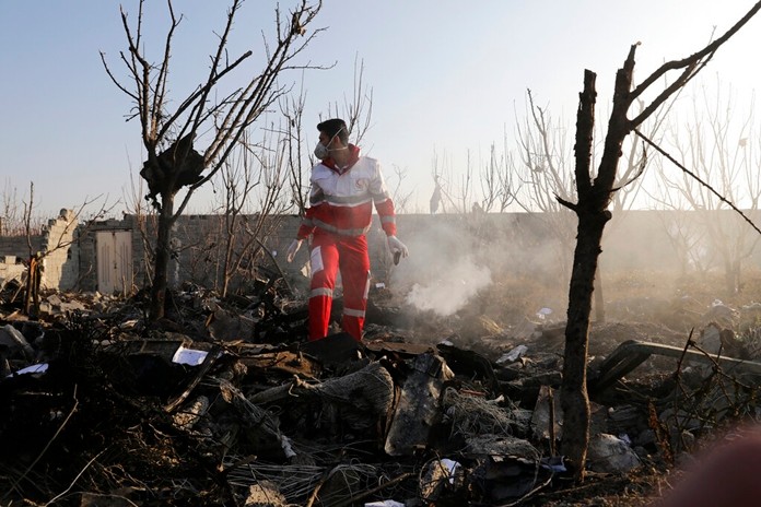 A rescue worker searches the scene where an Ukrainian plane crashed in Shahedshahr, southwest of the capital Tehran, Iran, Wednesday, Jan. 8, 2020.(AP Photo/Ebrahim Noroozi)