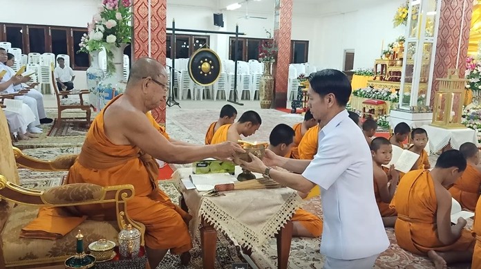 Banglamung District Chief Amnart Charoensri lit candles and lead prayers to the Triple Gems with Abbot Pipitkitjaruk at Nongprue Temple.