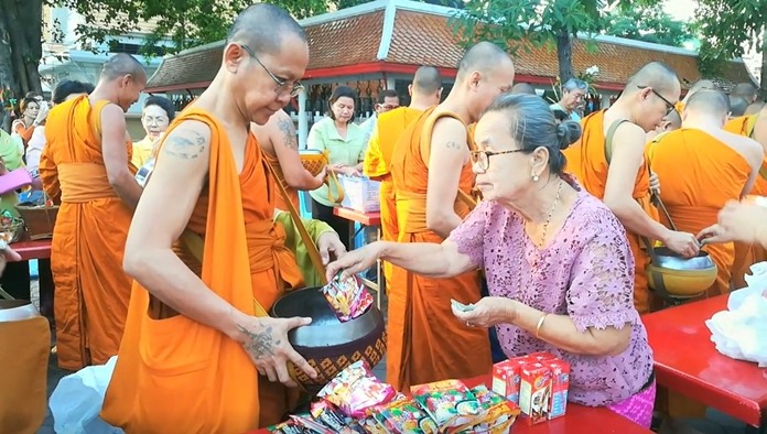 At Chaimongkol Temple, Thais and foreigners alike offered alms of rice and dried food to 50 monks.