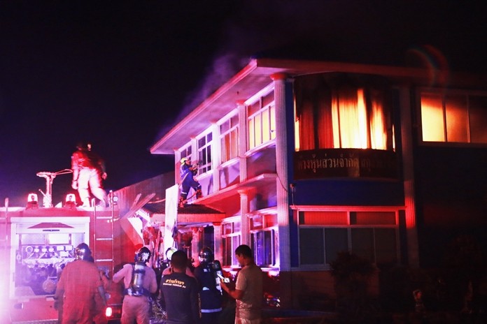 Firefighters battle a blaze on the second floor of the Sakulwit Supply Part., Ltd., in Bang Saray.