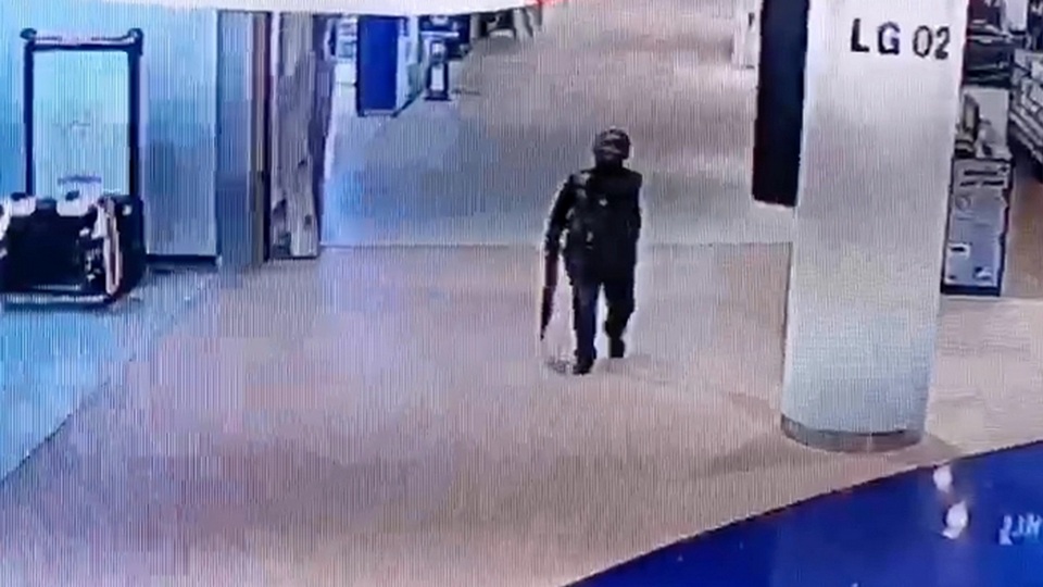 A CCTV grab shows the gunman holding his heavy weapon as he walks through Terminal 21 in Korat.