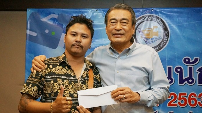 Deputy Mayor Ronakit Ekasingh presents an award to Pattaya Mail reporter Jetsada Homklin.