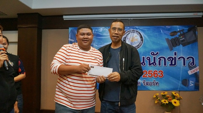 Pattaya Press Association Advisor Chaiyod Phupattanapong presents an award to Nation reporter Somball.