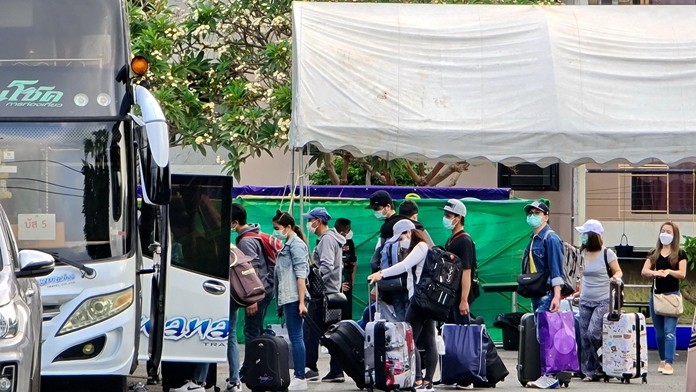 240 Thai overseas workers quarantined in Sattahip were sprayed with disinfectant and loaded on 16 buses at the Navy Hotel March 13 and sent off to their hometowns with 40 military escorts.