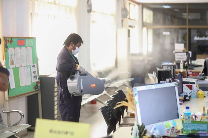 A sanitation worker spray disinfectant inside city hall.