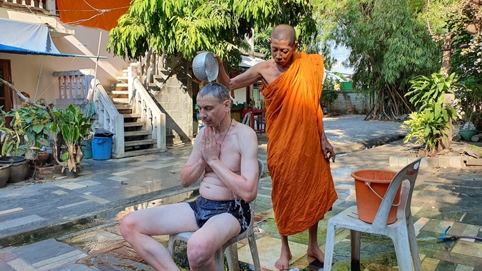 The deputy abbot at Wat Thepprasit Taothan, Boonsong Jantimo, better known as Luang Phu Aeed, wears a wry smile as he pours holy water over the head of a Russian tourist who believes this will save him from getting the coronavirus.