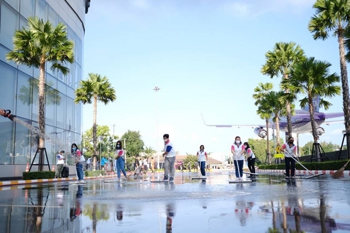 Staff roll up their sleeves to clean outside a shopping mall.