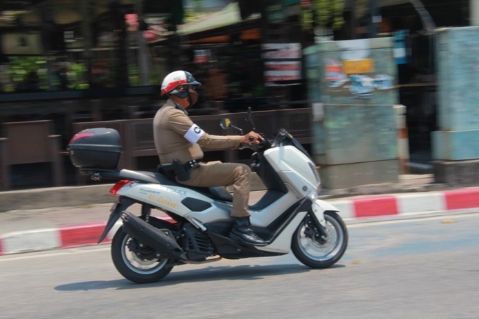 A motorbike policeman rides down Pattaya Beach Road when there is not much need to patrol.