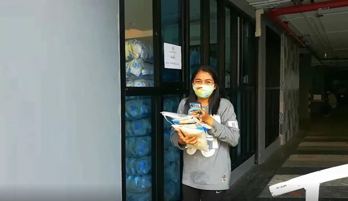 A lady is happy to receive her ration of rice and a face mask.