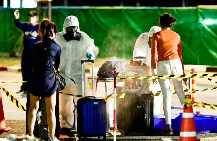 Arriving passengers are disinfected along with their luggage before being held in quarantine.