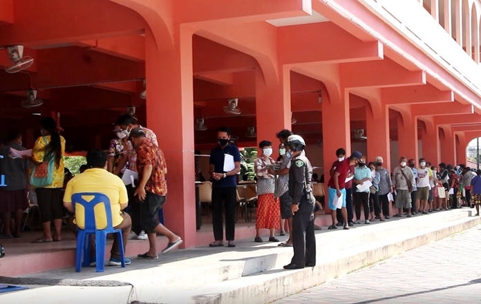 Thousands of Pattaya-area residents line up to apply for 1,000-baht stipends from Nongprue Subdistrict aimed at alleviating some of the economic pain of the coronavirus lockdown.