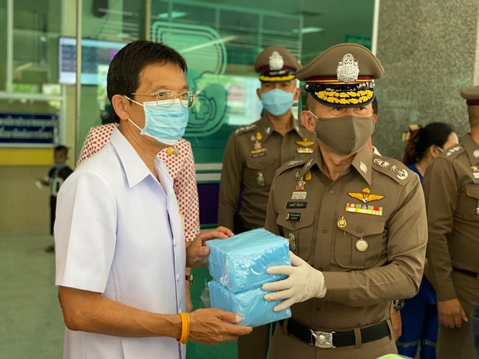 Pol. Lt. Gen. Montri Yimyam hands over facemasks to hospital director Dr. Narong Eakwattanakul and his staff.