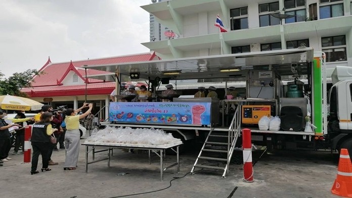 Amobile kitchen serving food to people at Wat Phai Tan community and Phaya Thai district in Bangkok.