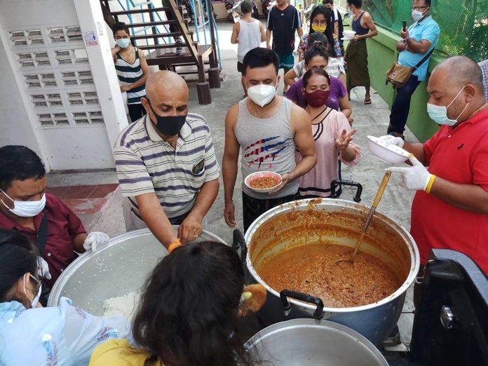 Volunteers perform community service by distributing food to the congregation.