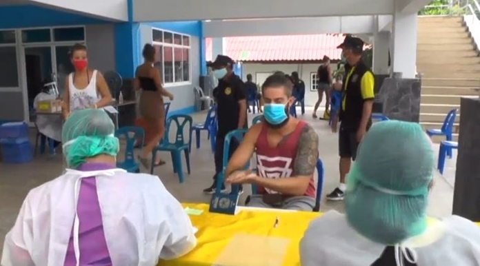 A tourist washes hi hands with staitizer gel as he talks to the medical staff.