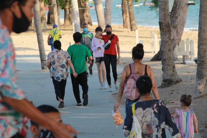 Tourists are walking along the clean and well paved footpath for exercises and leisure on a sunny day on Jomtien Beach,Pattaya City.