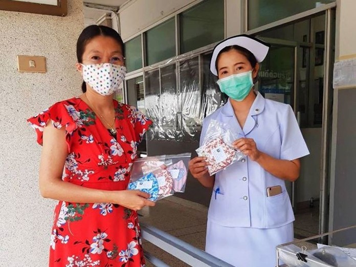 A HHN volunteer presents a collection of good quality cloth facemasks to the Wat Yansangwararam Hospital.