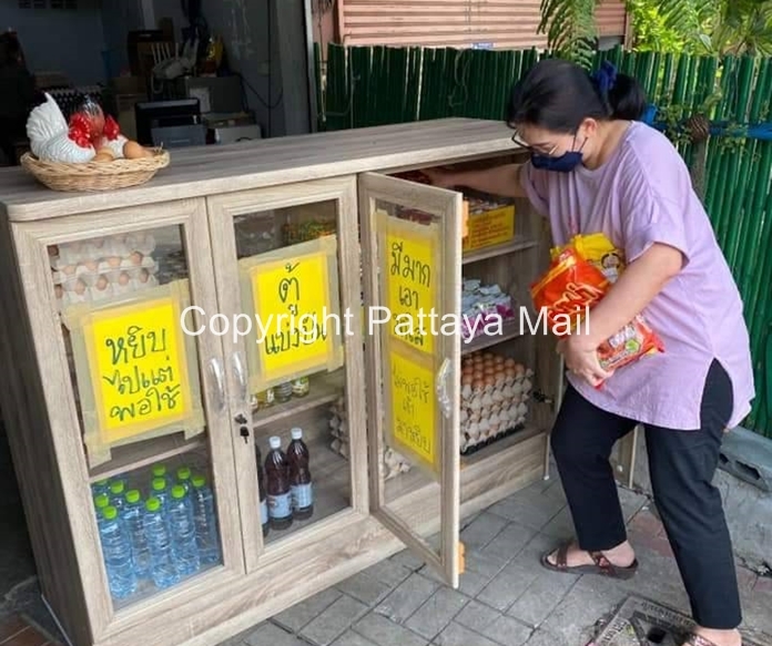 Residents in the area replenish the Food Sharing Cupboard with food supplies.