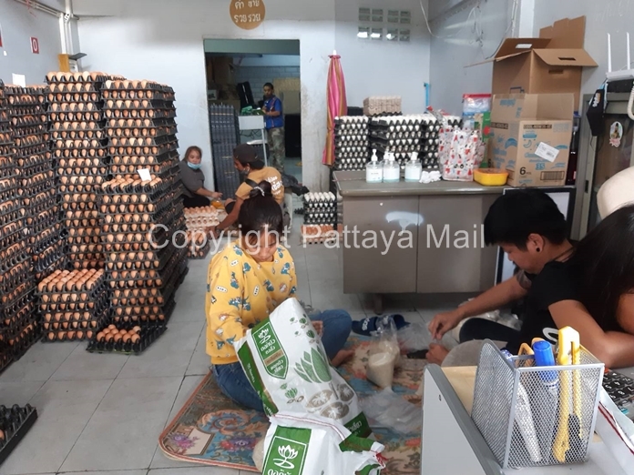 Staff of the See Pinong Khai Sod shop help to pack rice and other dried foodstuffs into small packages for the Food Sharing Cupboard.