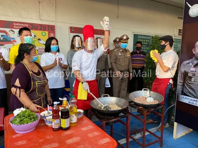 Pol. Col. Khemmarin Pissamai, dressed as a chef instead of his police uniform, cooks fried rice for the masses.
