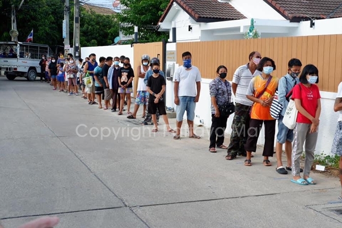 A long line of people advance slowly to the Gachoud house gate to receive a food package.