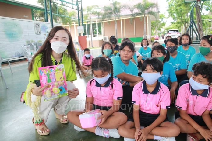 Beautiful women from the Chinese Tourists Assist Centre hand out toys to the children.