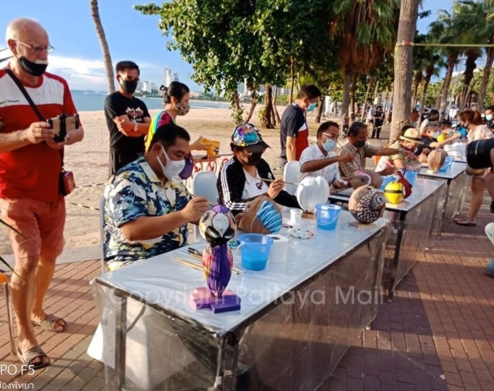 Mayor Sonthaya Kunplome (seated left) joins the fun painting coconuts to brighten the depressed pandemic atmosphere.