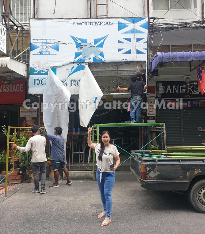 Workers tear down the Dog’s Bollocks Bar sign to replace it with the establishment’s new name, Number One June.