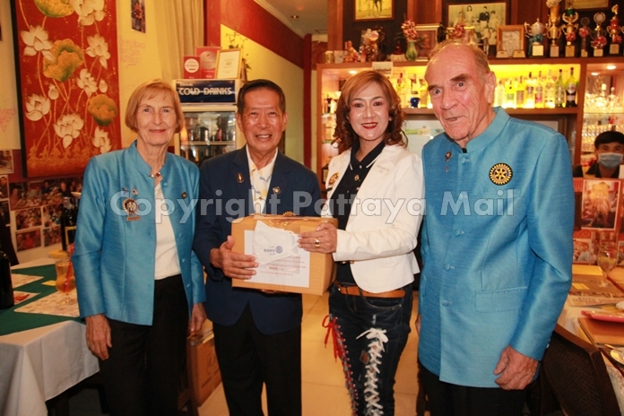 Pres. Maneeya Engelking of the Rotary E-Club Dolphin Pattaya International receives her box of face masks from DG Maruai. They are flanked by Dr Margret Deter (left) and Dr Otmar Deter.