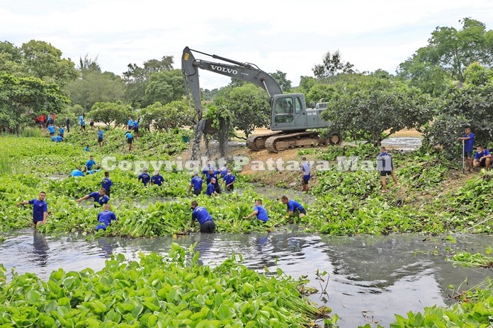 Conscripts from the Air and Coastal Defense Command use hand tools and heavy machinery to clean hyacinth out of the Juk Samet Canal to help reduce flooding.