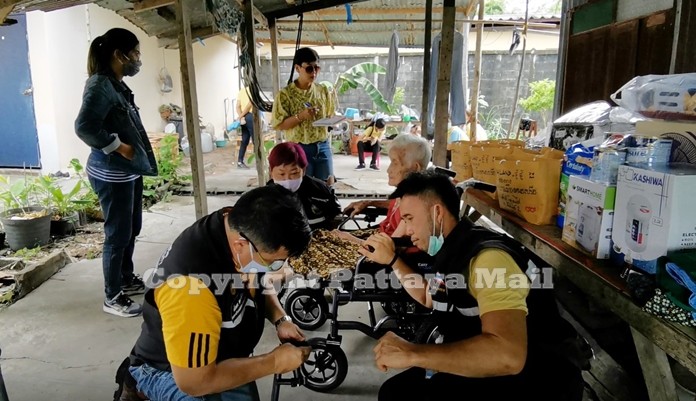 Nongprue officials adjust Grandma Yasothin’s new electric wheelchair.