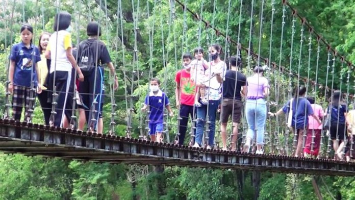At Khao Kradong Forest Park, in Buriram province, tourists at Khao Kradon Forest Park are required to check the body temperatures before entering the premises and ascend the Naga Bridge to enjoy the stunning views of the volcano.