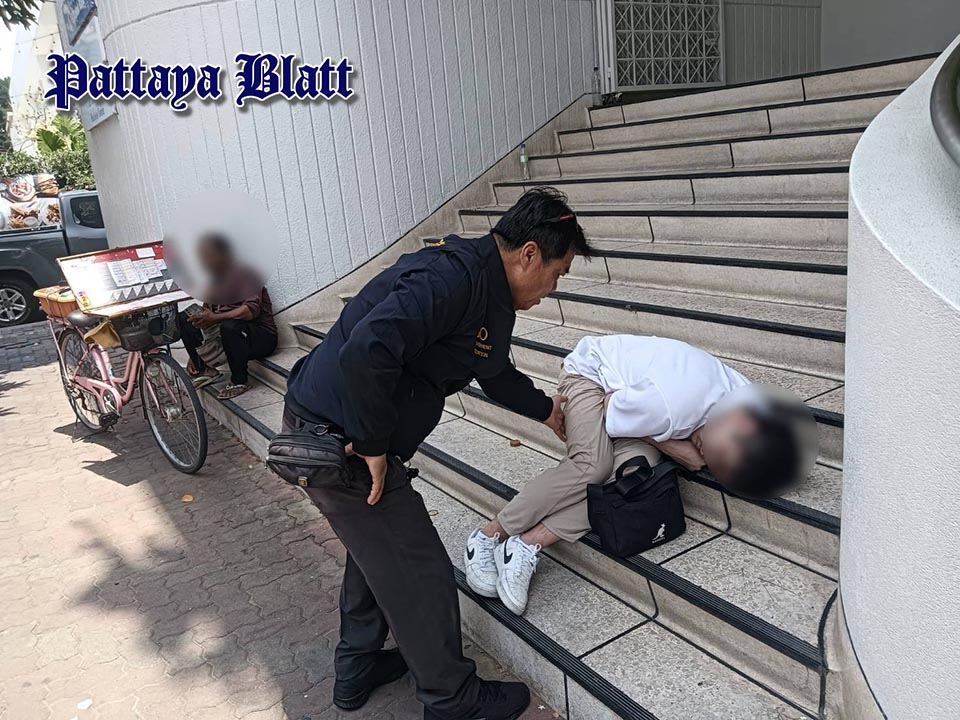 Städtische Beamte helfen betrunkenem Touristen auf Banktreppe in Pattaya