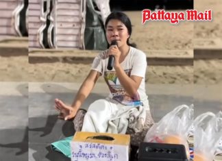 Young Pattaya mother sings on beachfront to feed her baby son